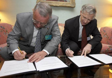 Swiss Ambassador Robert Mayor (right) signs the Framework Arrangement with the Forum of Federations while former Swiss President Arnold Koller (left) signs on behalf of the Forum.